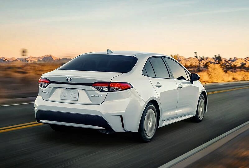 Rear end of 2022 Corolla Hybrid as car drives on a secluded road at dusk