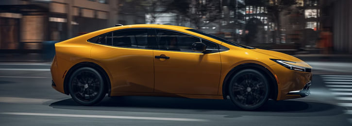 Yellow Toyota Prius on a city street.