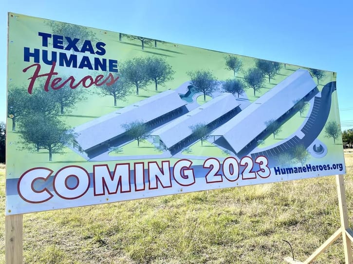 Billboard showing a building design for "Texas Humane Heroes" against a backdrop of trees. Large text reads "COMING 2023." URL: HumaneHeroes.org.