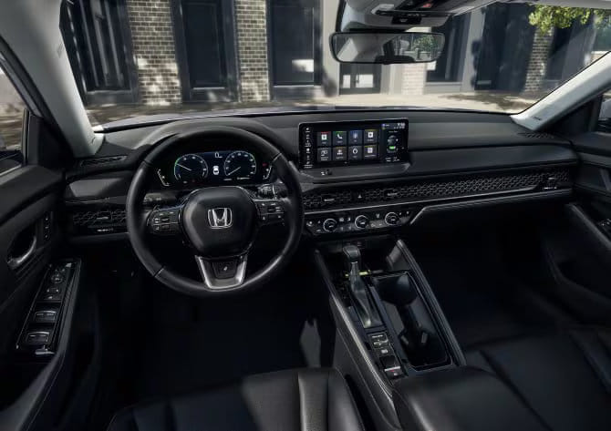 Interior view of the 2025 Honda Accord LX with cloth seats, showcasing the modern dashboard and driver-centric layout.