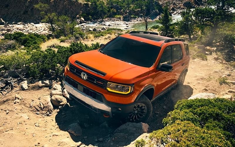A 2026 Honda Passport navigating a rocky trail, showcasing its off-road capabilities and rugged design.