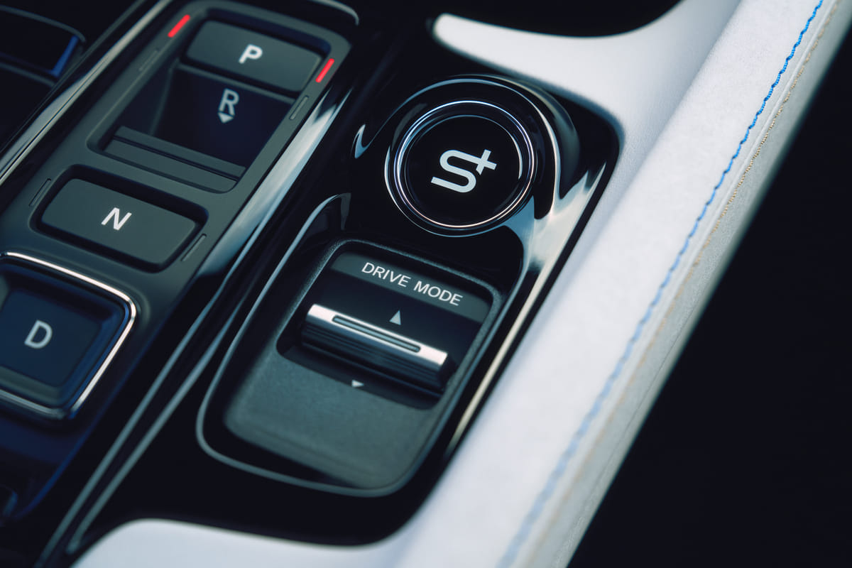 A close-up of the 2026 Honda Prelude's center console, focusing on the push-button gear selector and the prominent round button for the new S+ drive mode.