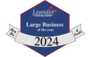 Hexagonal badge with a banner reads 'Large Business of the Year 2024' from Leander Chamber of Commerce. Blue background with red border conveys prestige.