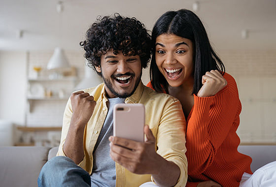 Una pareja feliz comprueba la oferta en su teléfono móvil.