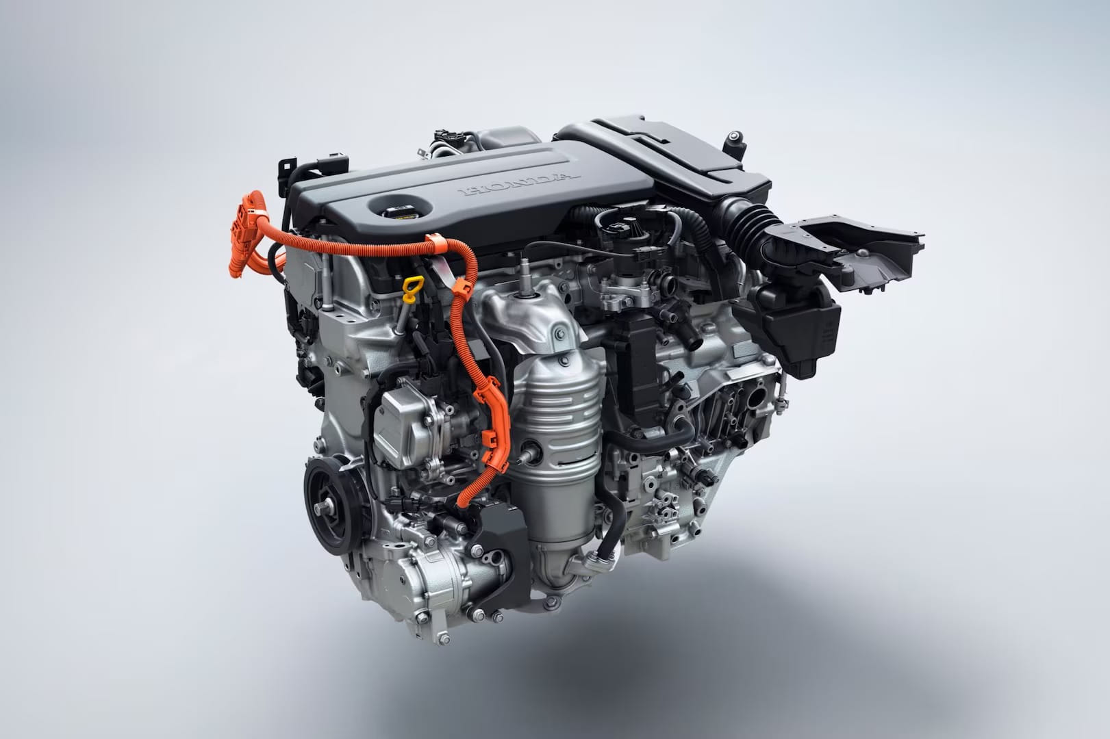 Close-up of a car engine showing intricate metal parts and orange cables on a neutral background. The sleek design suggests modern, efficient technology.