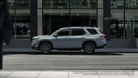 2023 Honda Pilot Sport se muestra en Sonic Gray Pearl con barras transversales de accesorios de pie junto al edificio