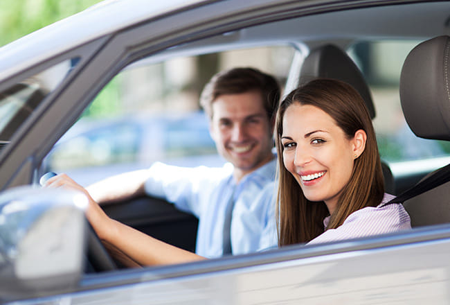 Smiling couple sitting inside a car