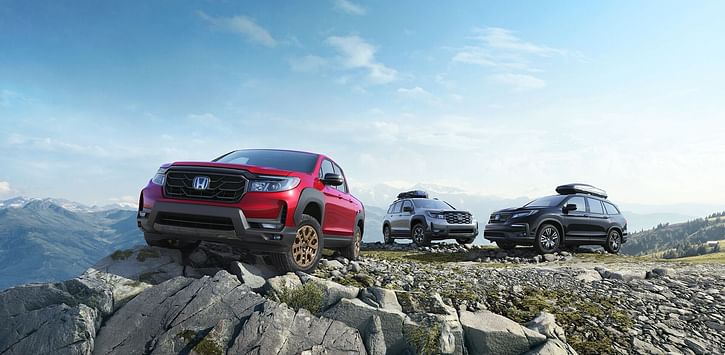 Red Honda Ridgeline and Hondas SUV parked on the top of the mountain 