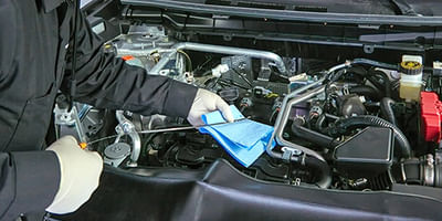 Mechanic checking oil level in the car