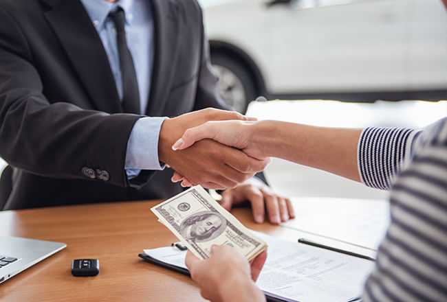 Customer and a dealership representative shake hands.