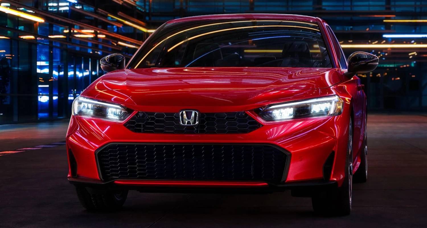 El Honda Civic Sedan Sport Touring Hybrid 2025 en Rallye Red en un entorno exterior