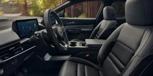 Interior del 2026 Honda Prologue Elite, con la cabina, el tablero, el volante y el área de asientos desde una vista lateral.