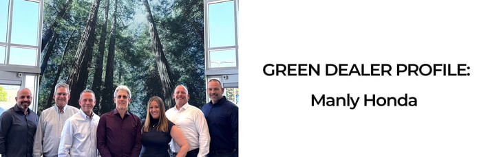 Group of seven people standing together and smiling in front of a large indoor mural of tall green trees, under the title 'Green Dealer Profile: Manly Honda' displayed on the right side of the image.