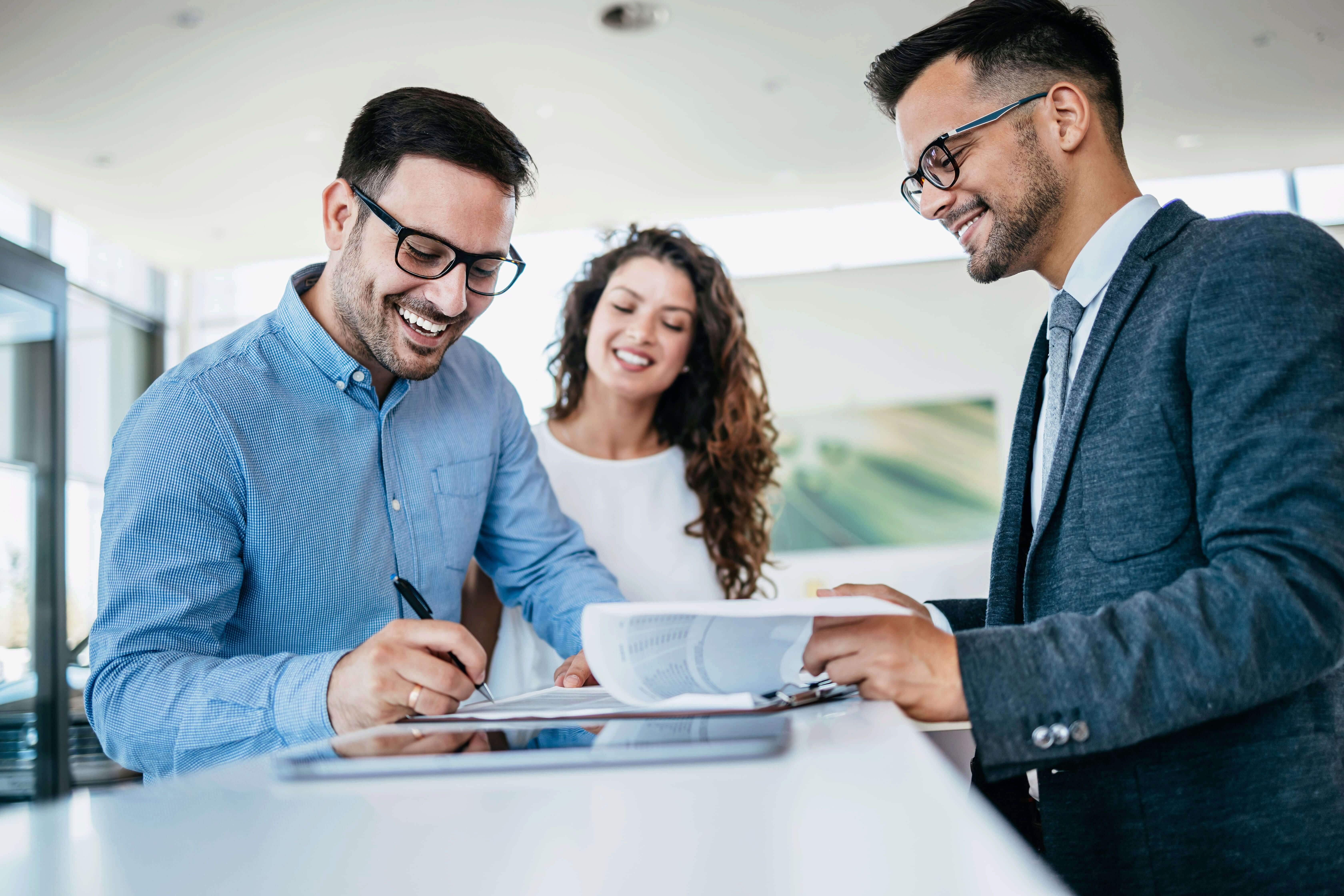 Dos clientes firman un contrato con el vendedor