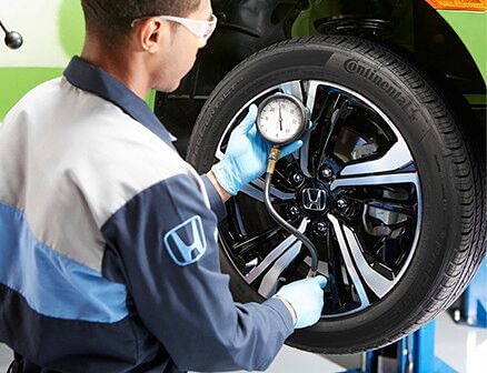 service technician checking tire pressure