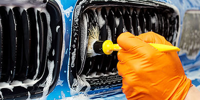 Hand in the glove washing a front of a car