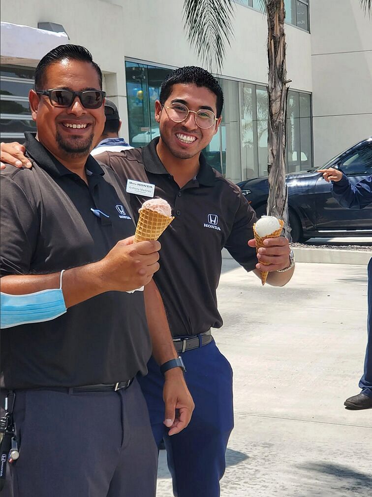 Two workers smiling and holding ice cream