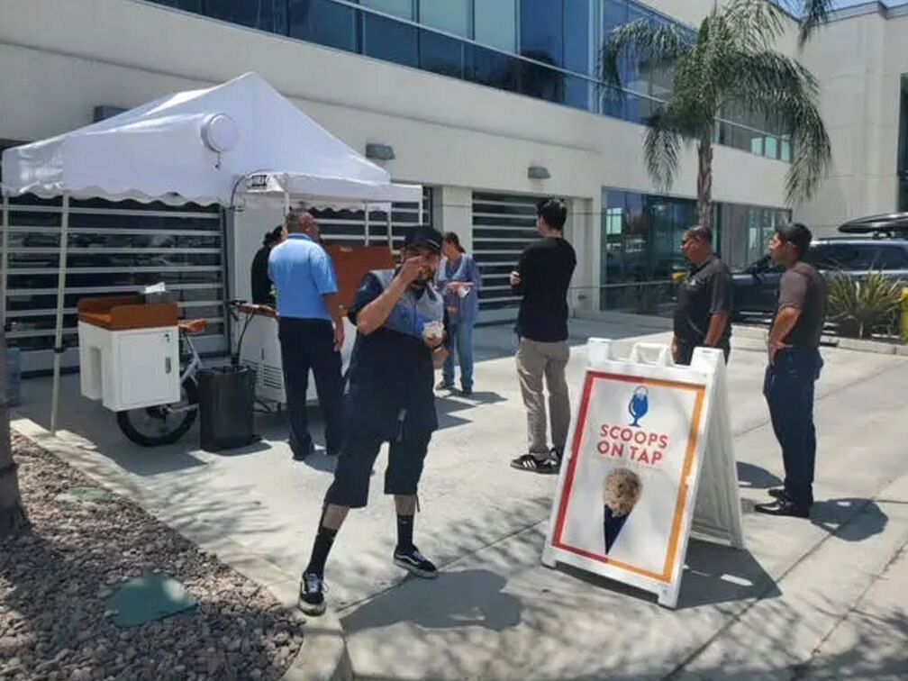 People pose by the ice cream cart for a photo