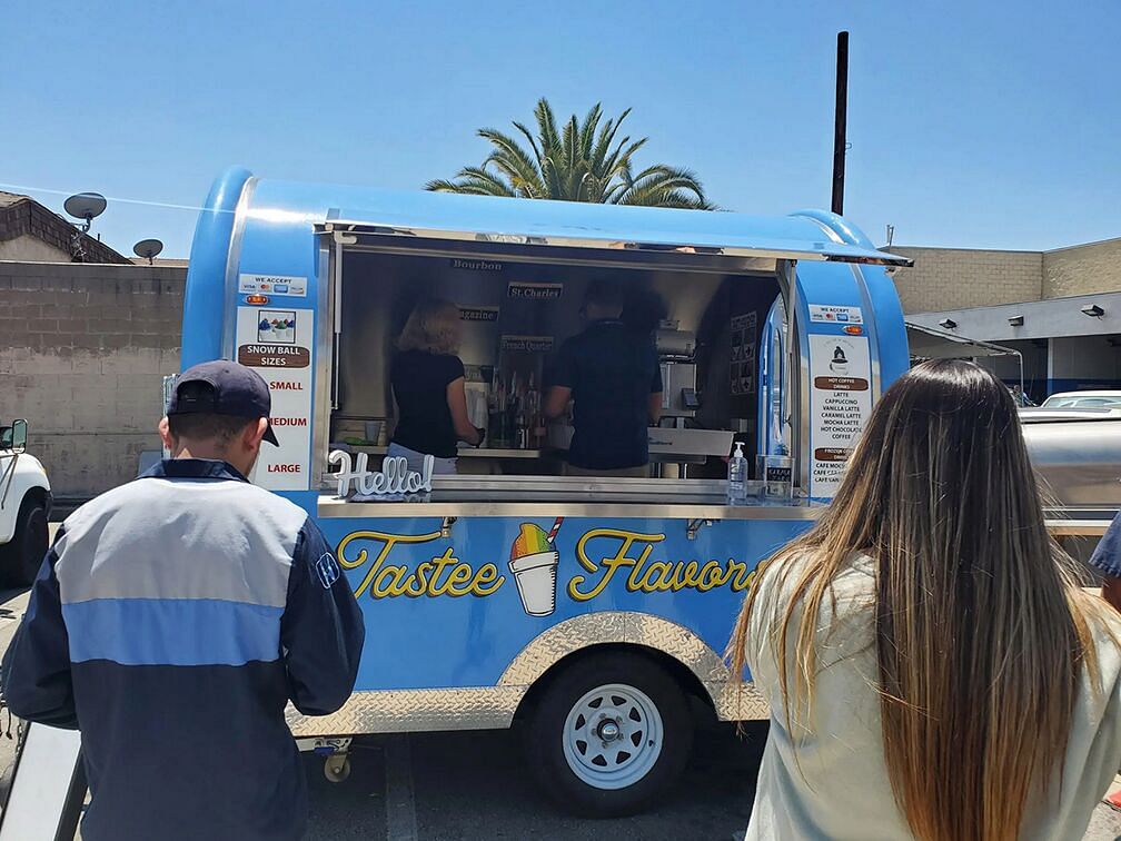 people stand in front of a food truck