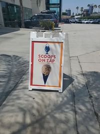 ice cream advertisement on a board placed on the street