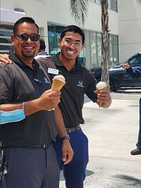 two workers smiling and holding ice cream