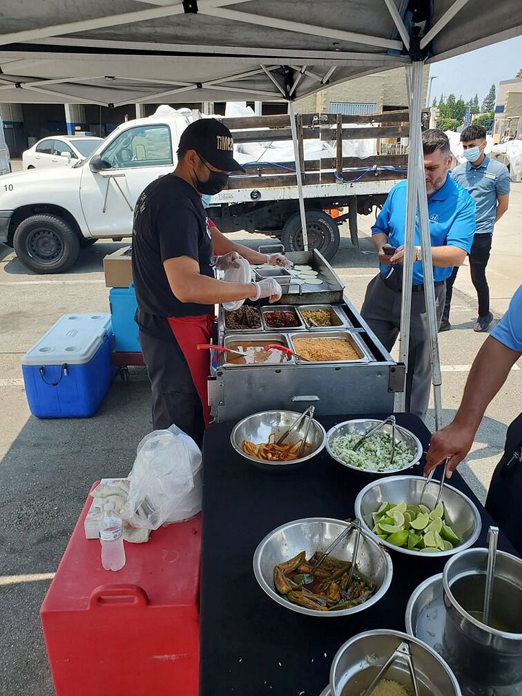 Workers prepare tacos