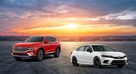 Hyundai Santa Fe and Honda Civic overlooking a city during sunset.