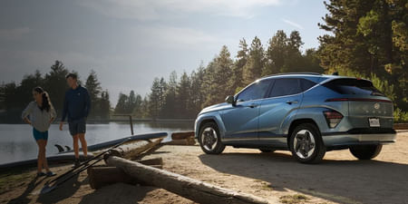 A silver Hyundai Kona parked by the lake.