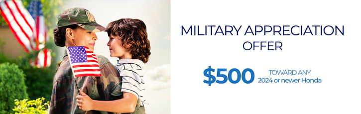 Woman in military uniform holding an American flag and embracing a young boy. Text on the right reads: 'Military Appreciation Offer – $500 toward any 2024 or newer Honda.'