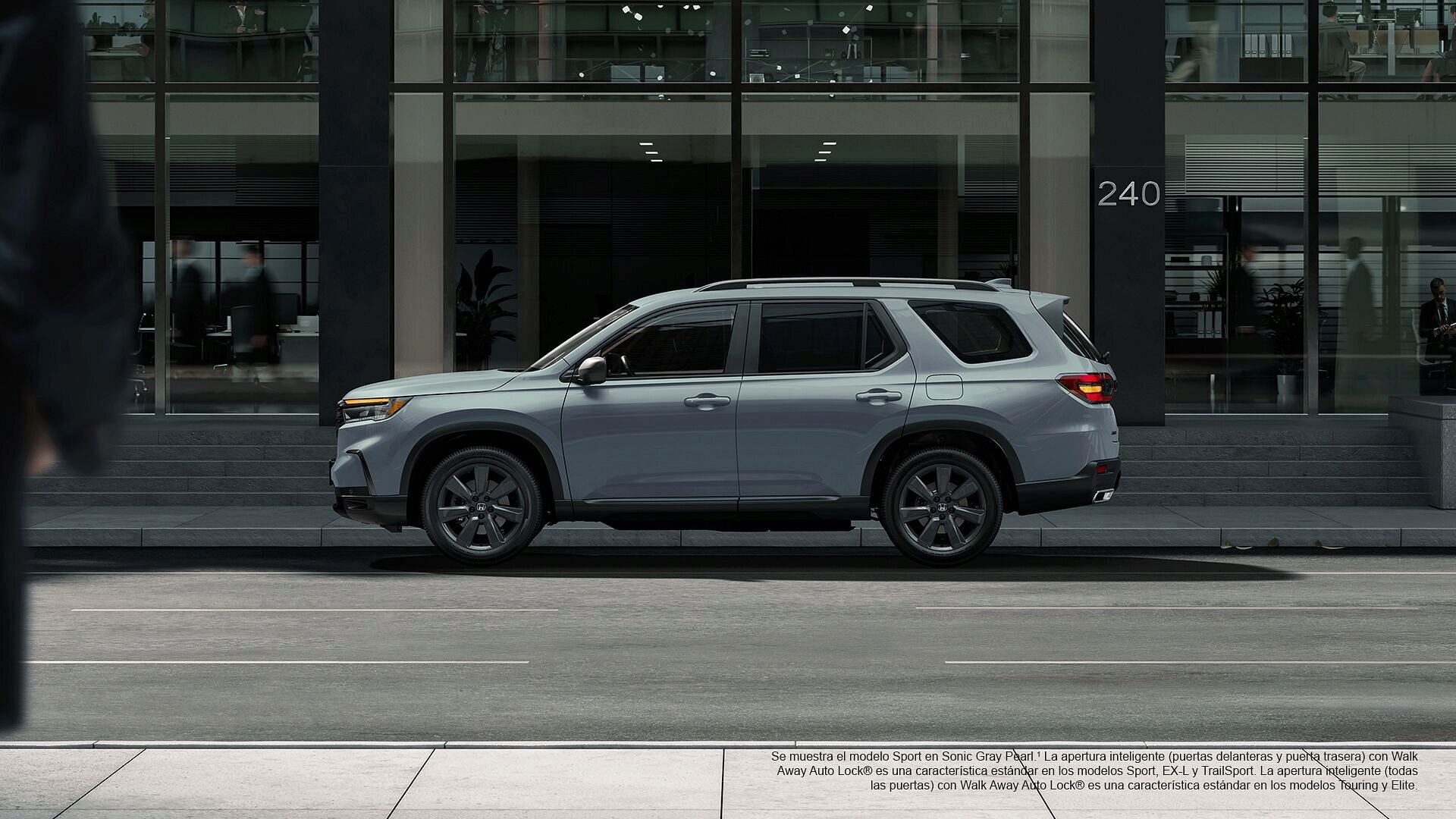 2023 Honda Pilot Sport se muestra en Sonic Gray Pearl con barras transversales de accesorios de pie junto al edificio