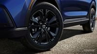 A wheel of Canyon river blue metallic honda 2023 sport touring hybrid.
