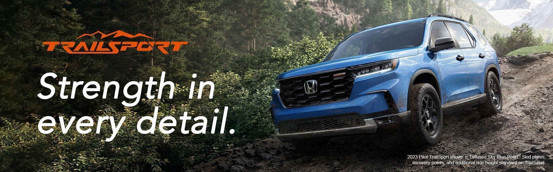 2023 Honda Pilot TrailSport shown in Diffused Sky Blue Pearl. Skid plates, recovery points, and additional ride height standard on TrailSport. Honda driving on mountain wilderness roads