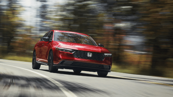 2026 Honda Accord driving in a forest environment taking the curve of the road.