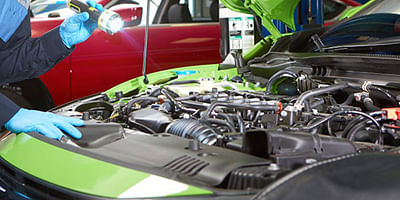 Technician checking under the hood of the car