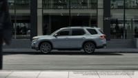 2023 Honda Pilot Sport se muestra en Sonic Gray Pearl con barras transversales de accesorios de pie junto al edificio