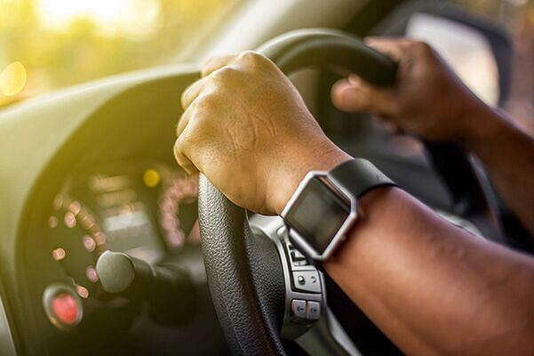 Close up shot of hands on wheel of vehicle