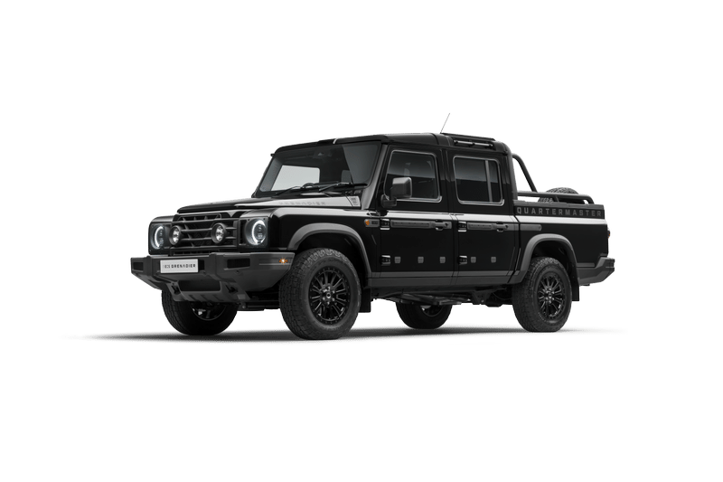 A black, Ineos Grenadier Quartermaster with off-road tires and sleek design is showcased on a dark background, conveying toughness and sophistication.