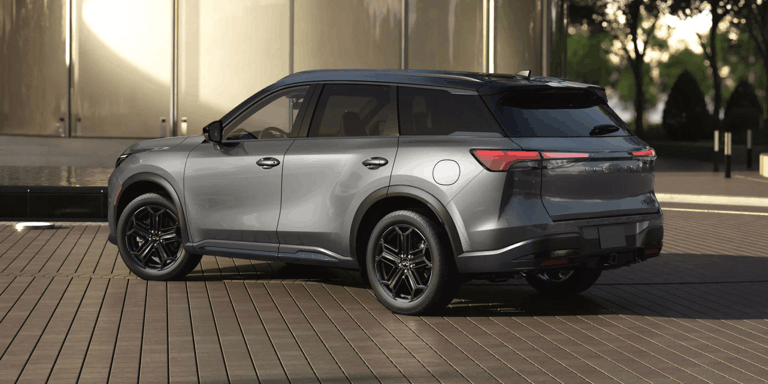 Rear three-quarter view of a 2026 INFINITI QX60 in Harbor Gray exterior.