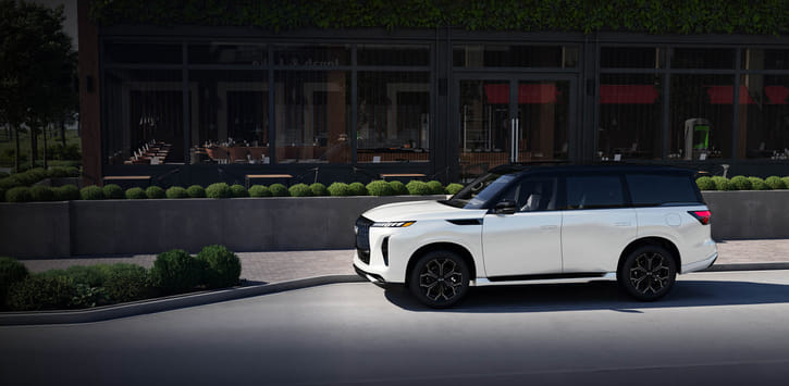 2026 QX80 parked outdoors with modern building visible in the background.