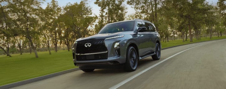 Exterior front profile of 2026 INFINITI QX80 Luxury SUV driving down the road.