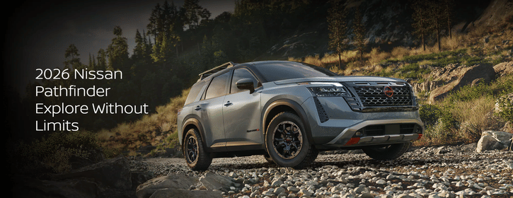 2026 Nissan Pathfinder driving along a dusty dirt road at sunset, with golden light behind the vehicle.