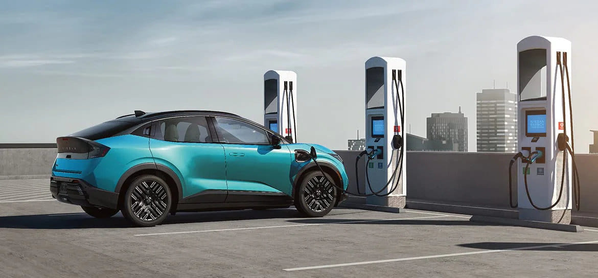 The 2026 Nissan Leaf plugged into a charging station, highlighting its efficient EV technology and modern design.