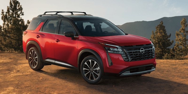 2026 Nissan Pathfinder parked on a dirt clearing with mountain peaks visible in the distant background.