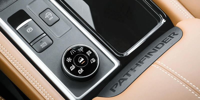 2026 Nissan Pathfinder center console with the driver’s hand turning the Drive Mode Selector knob.