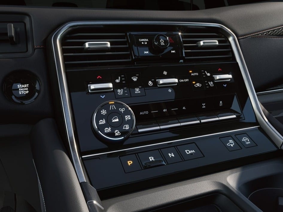 Close-up of a 2026 Nissan Armada dashboard interface featuring controls for climate, audio, gear shift, and engine start/stop button.