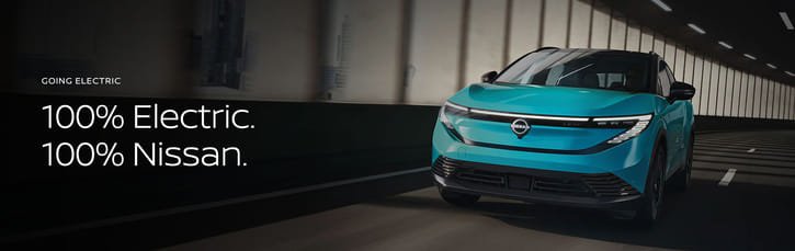 2026 Nissan LEAF in blue driving on curve with beams behind it.