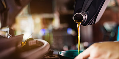 Mechanic replacing fluid in the vehicle 