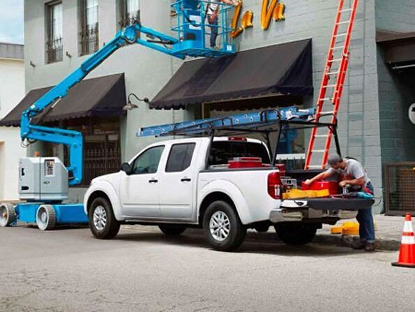 white nissan standing on construction site