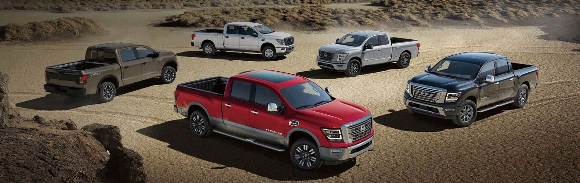 5 Nissan trucks parked on the desert