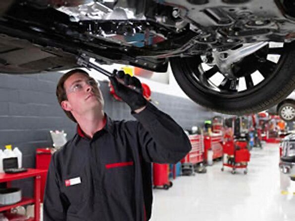 serviceman inspecting the car's chassis